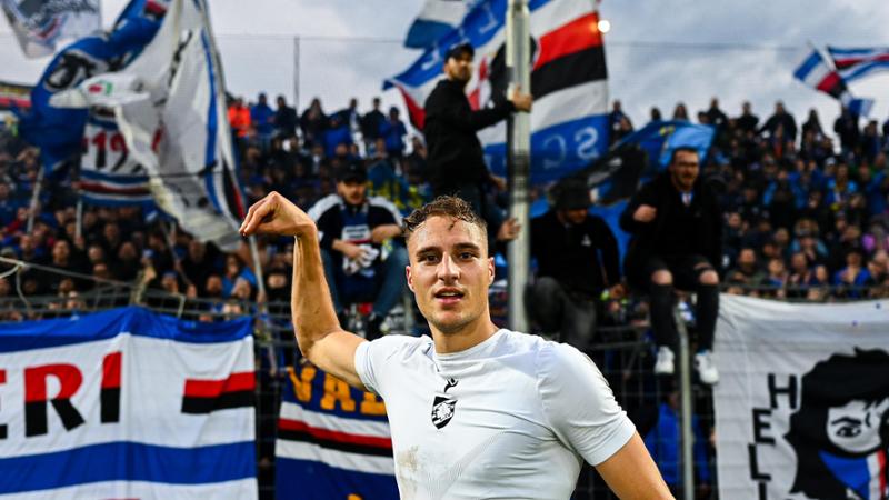 Un uomo in maglietta davanti ai tifosi della Sampdoria fa il segno del cigno con la mano 