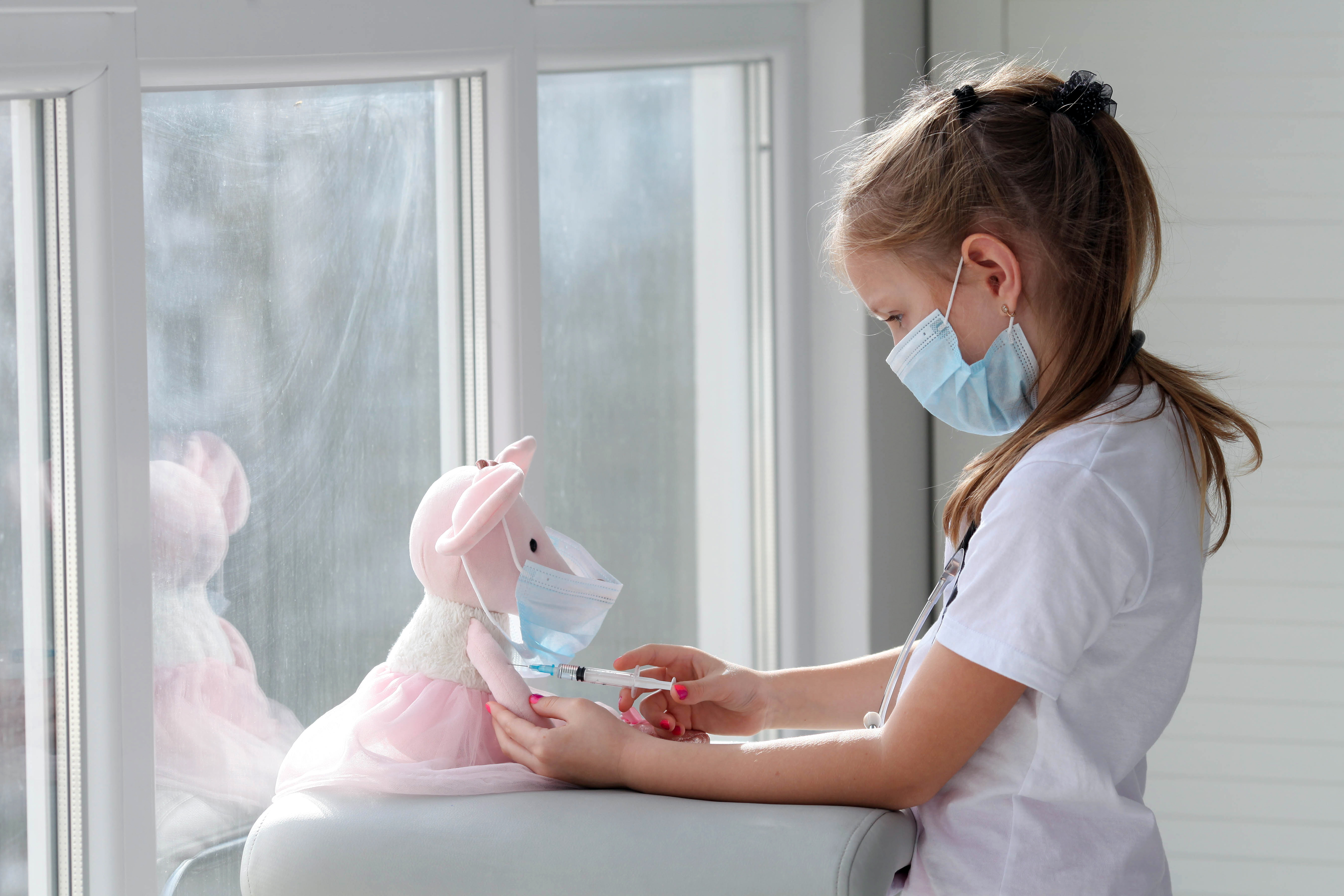 Ogni anno in Italia circa 2.200 bambini e adolescenti ricevono una diagnosi di tumore pediatrico Bambina con mascherina che fa iniezione a un peluche
