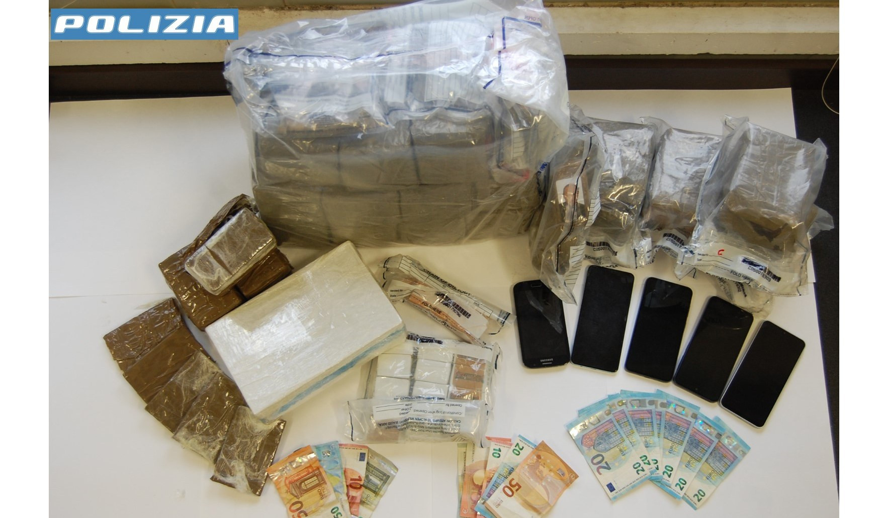 Panetti di hashish e contante su un tavolo bianco