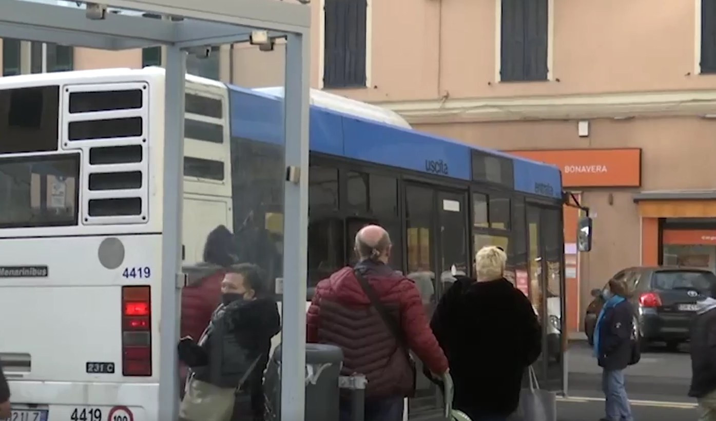 Diverse persone alla banchina in attesa dell'autobus, dietro un mezzo appena arrivato
