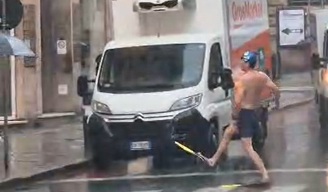 Piove a Genova, in via XX spunta un ragazzo con pinne e costume da bagno