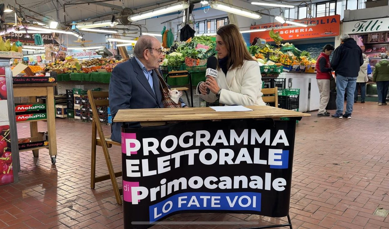 Il banchetto di Primocanale al mercato di piazza Terralba a Genova Due persone sedute a un tavolo