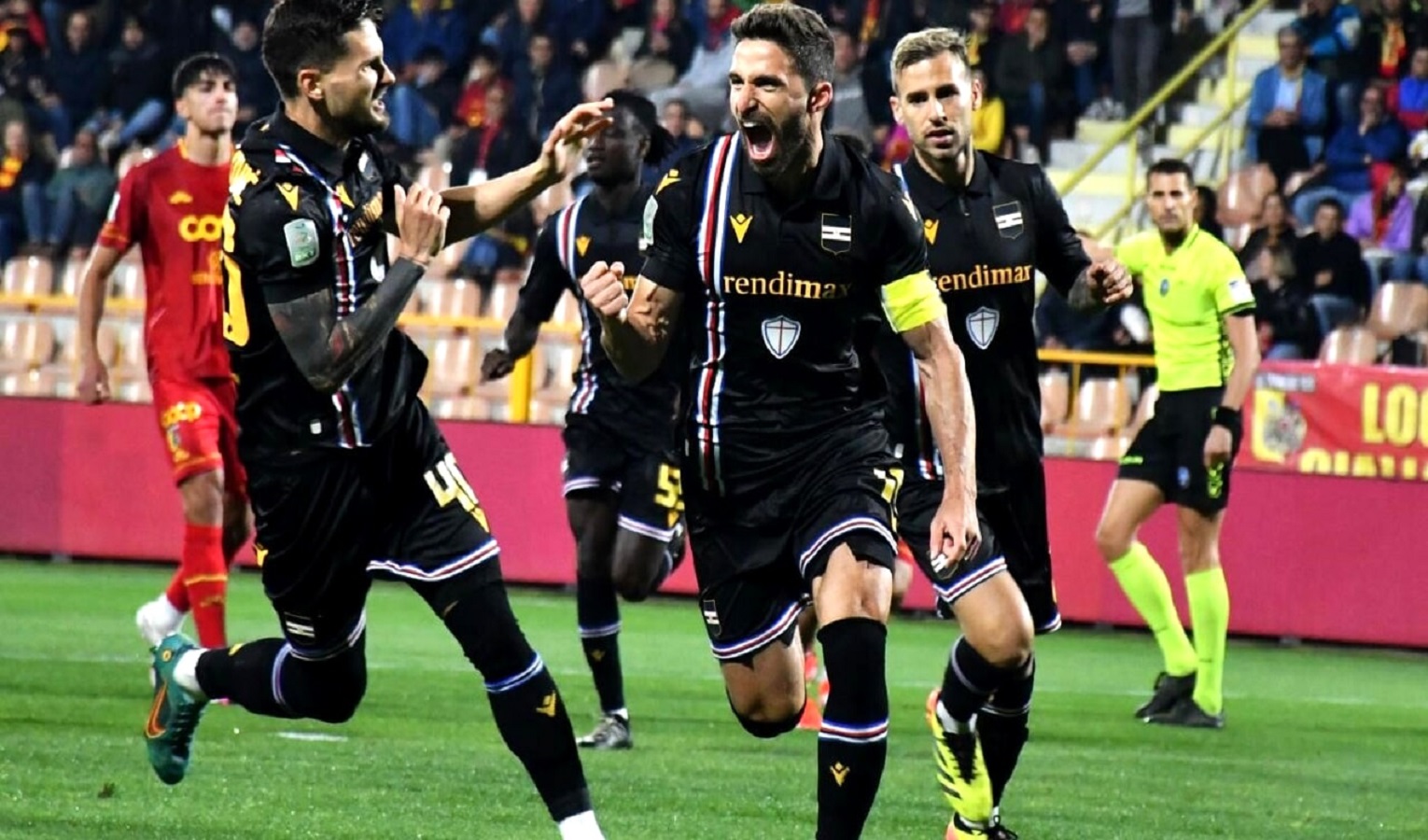 Un calciatore esulta e viene seguito dai compagni di squadra