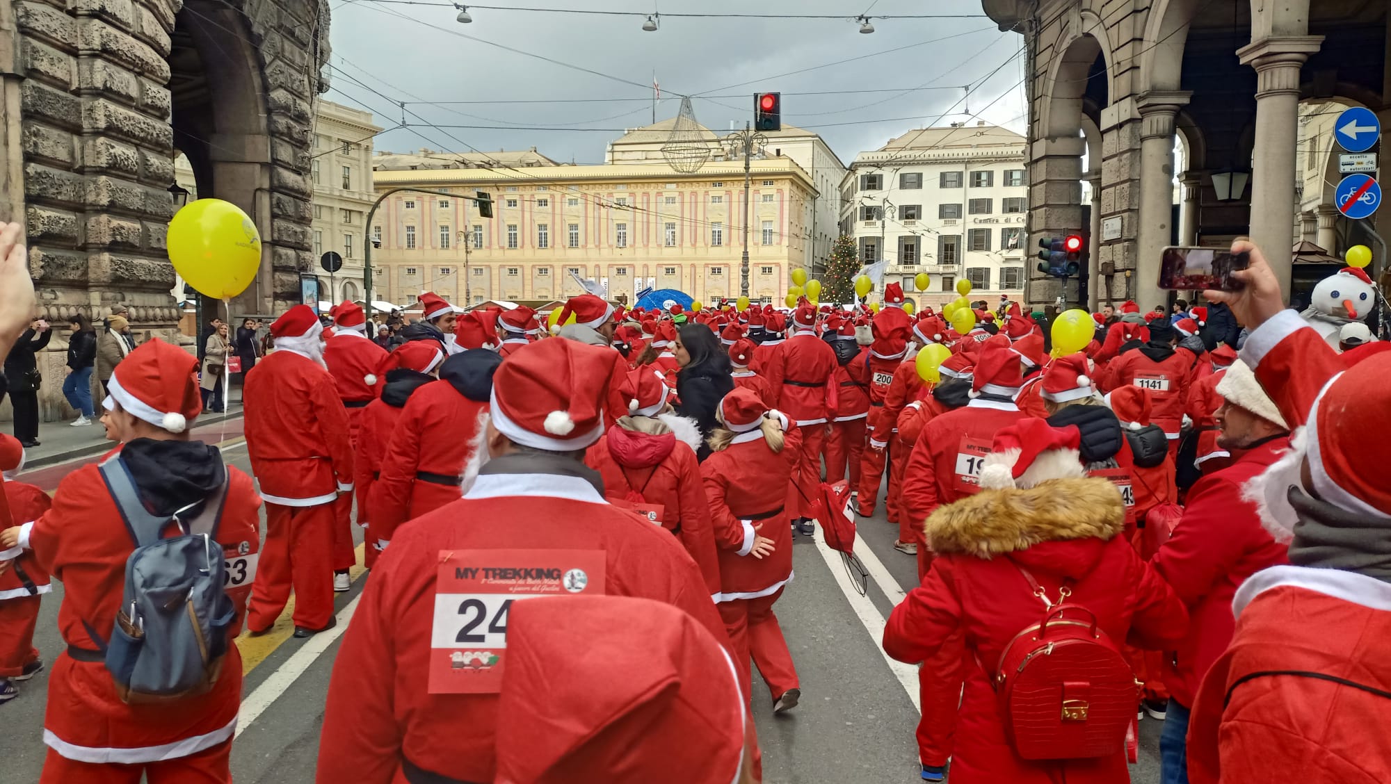 Persone vestite da babbo natale camminano in una strada