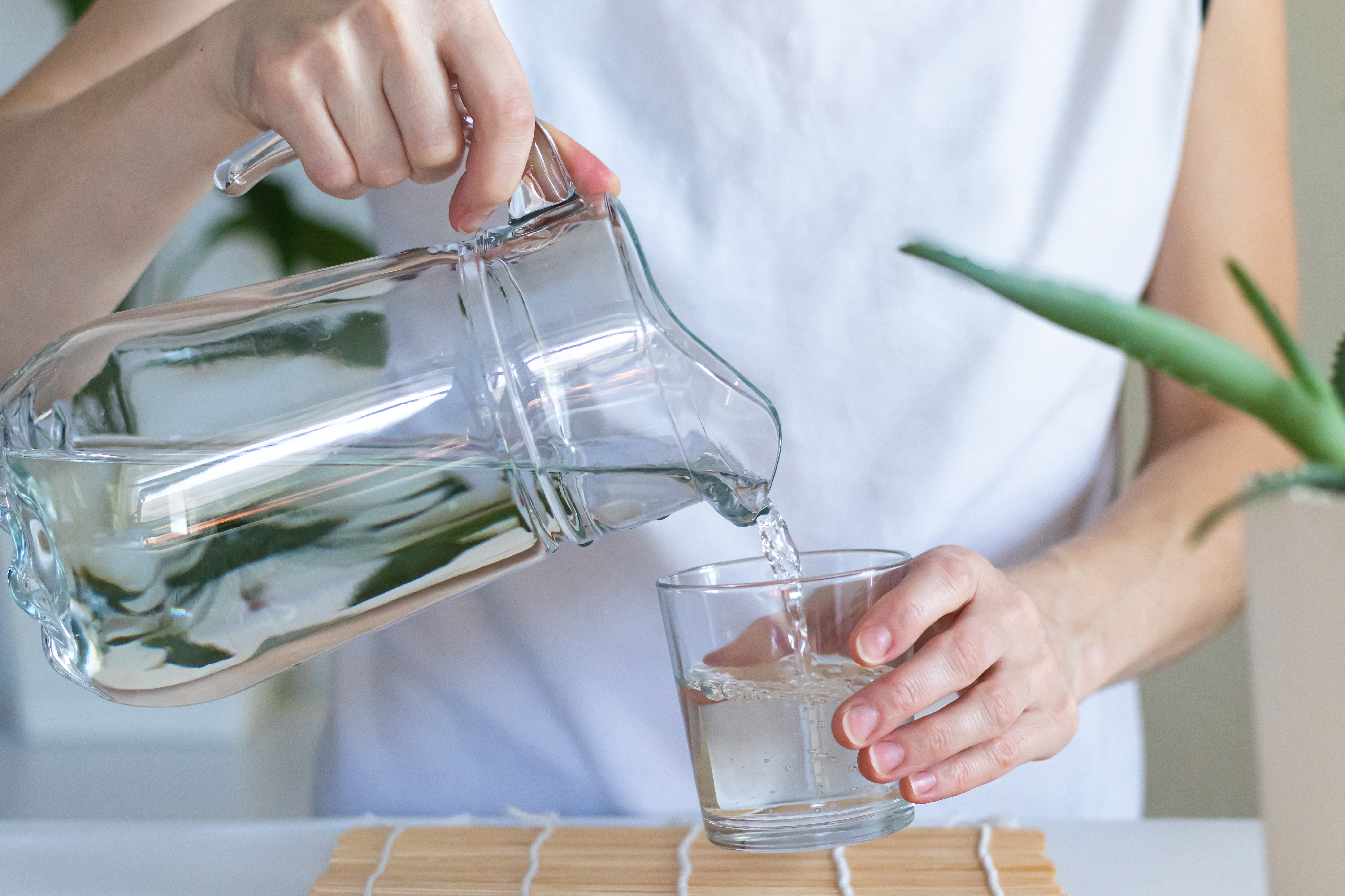 Acqua versata in un bicchiere da una brocca