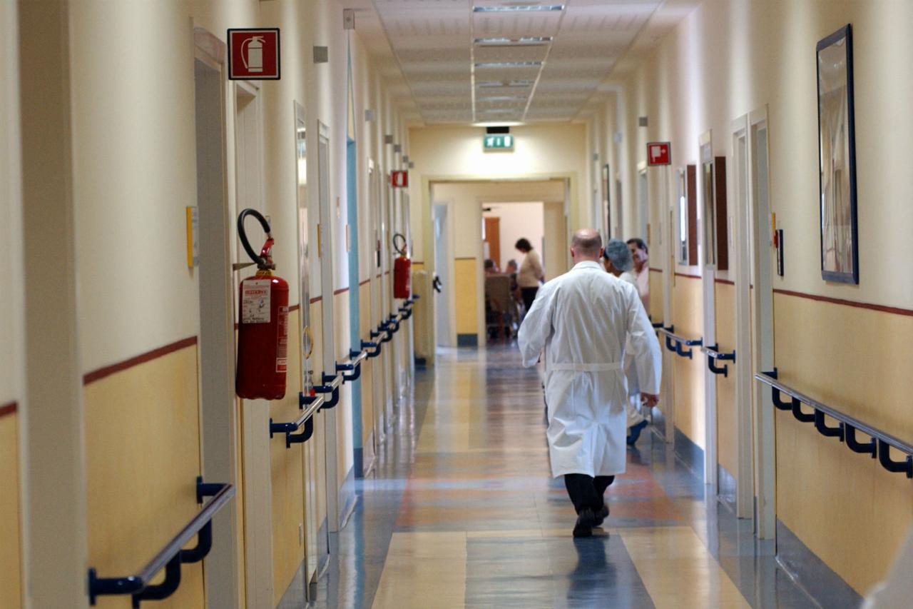 Gli interni di un ospedale Gente che cammina in corridoio, uno con un camice bianco