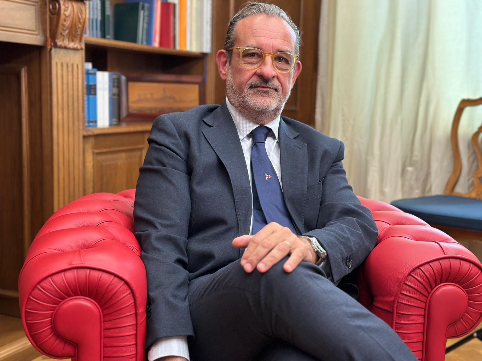 Un signore seduto su una poltrona rossa 