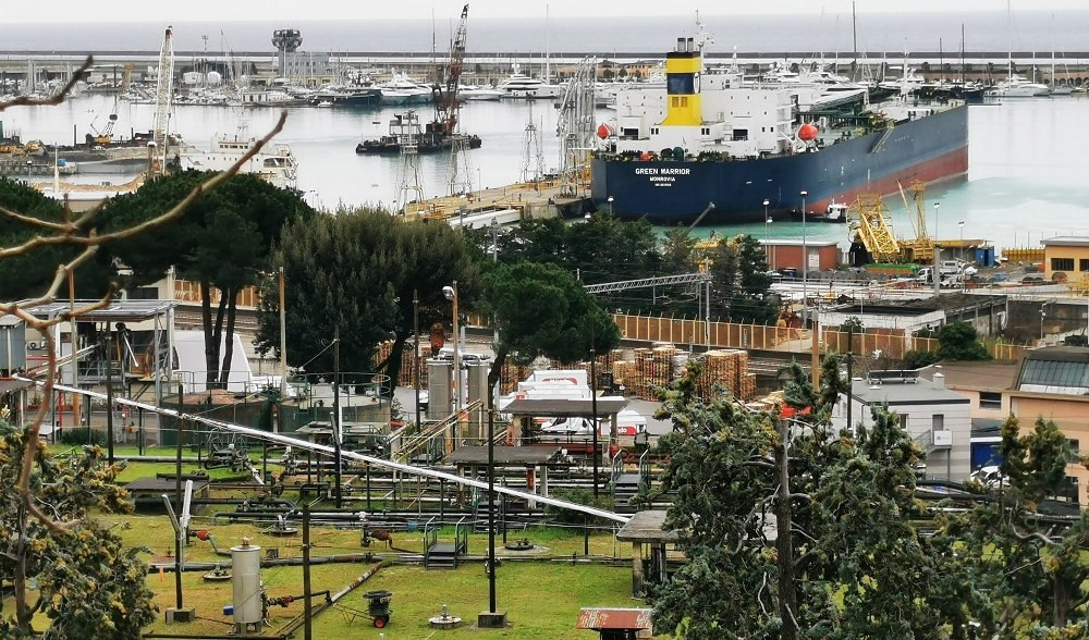 I depositi costieri a Genova Multedo Tanti tubi e serbatoi in un prato e accanto al mare con delle navi
