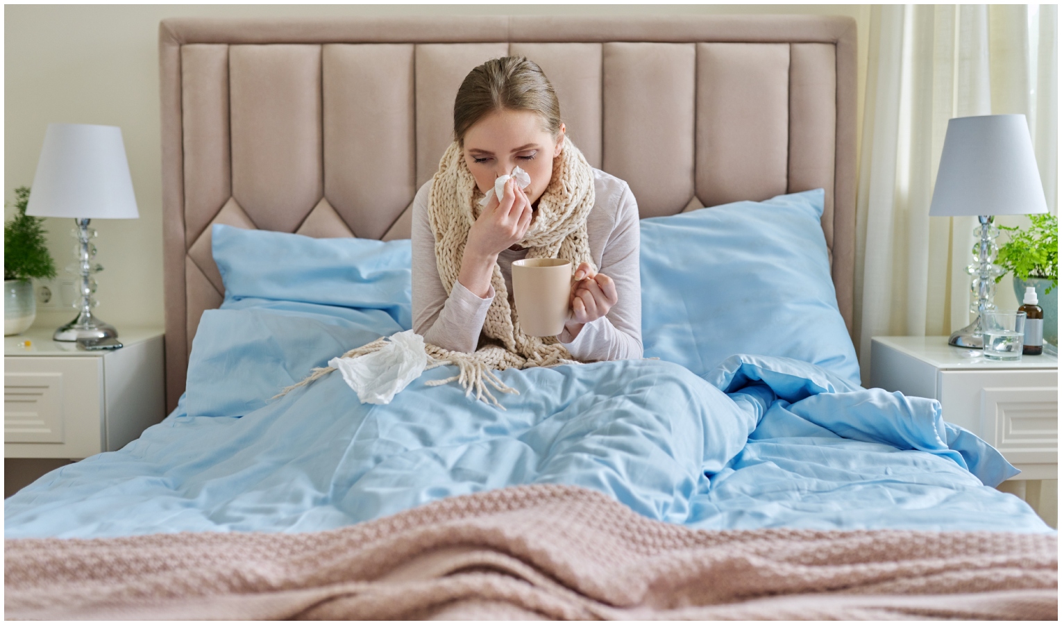 Donna che si soffia il naso malata a letto