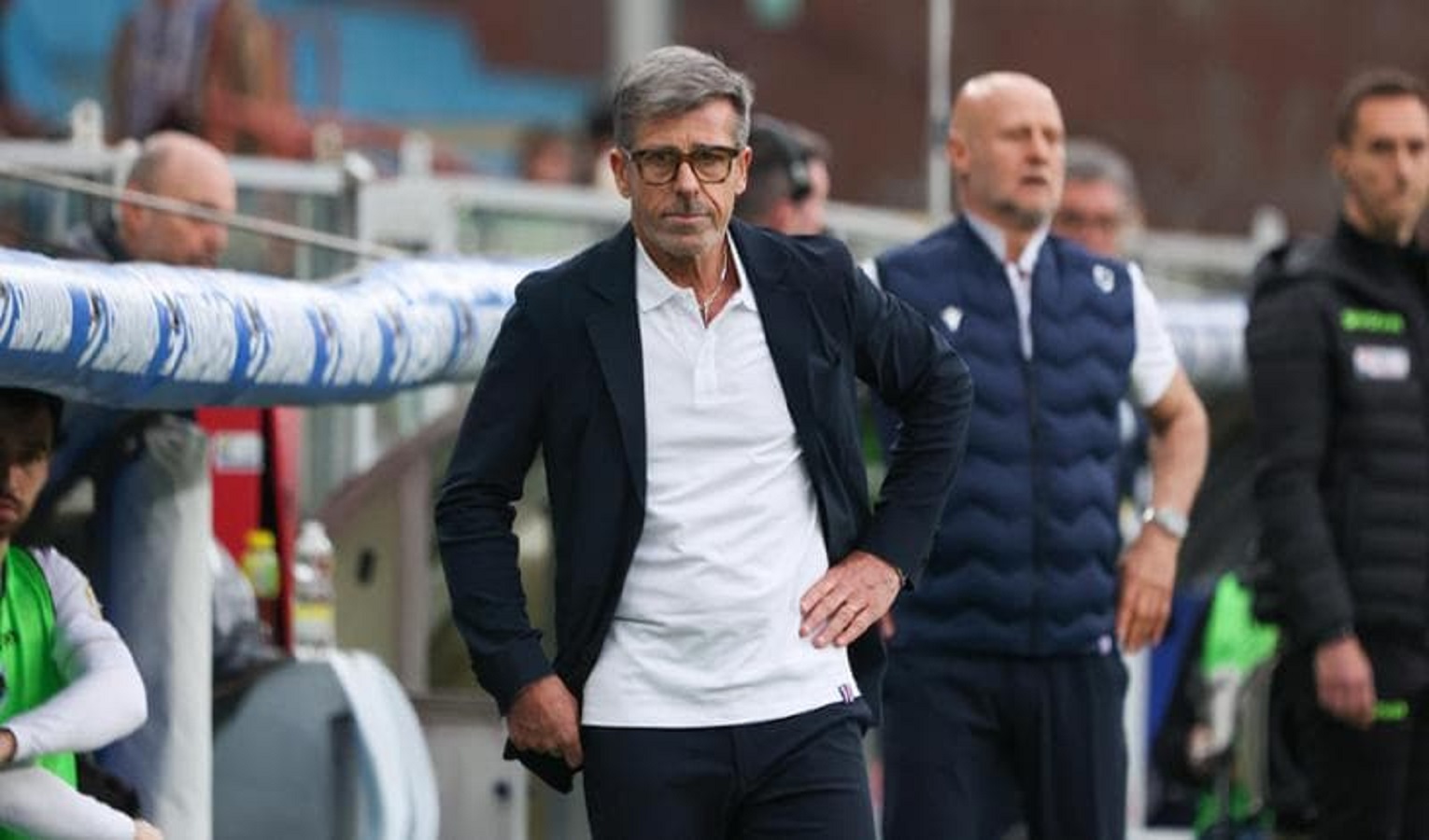 Due uomini vicino a una panchina su un campo da calcio