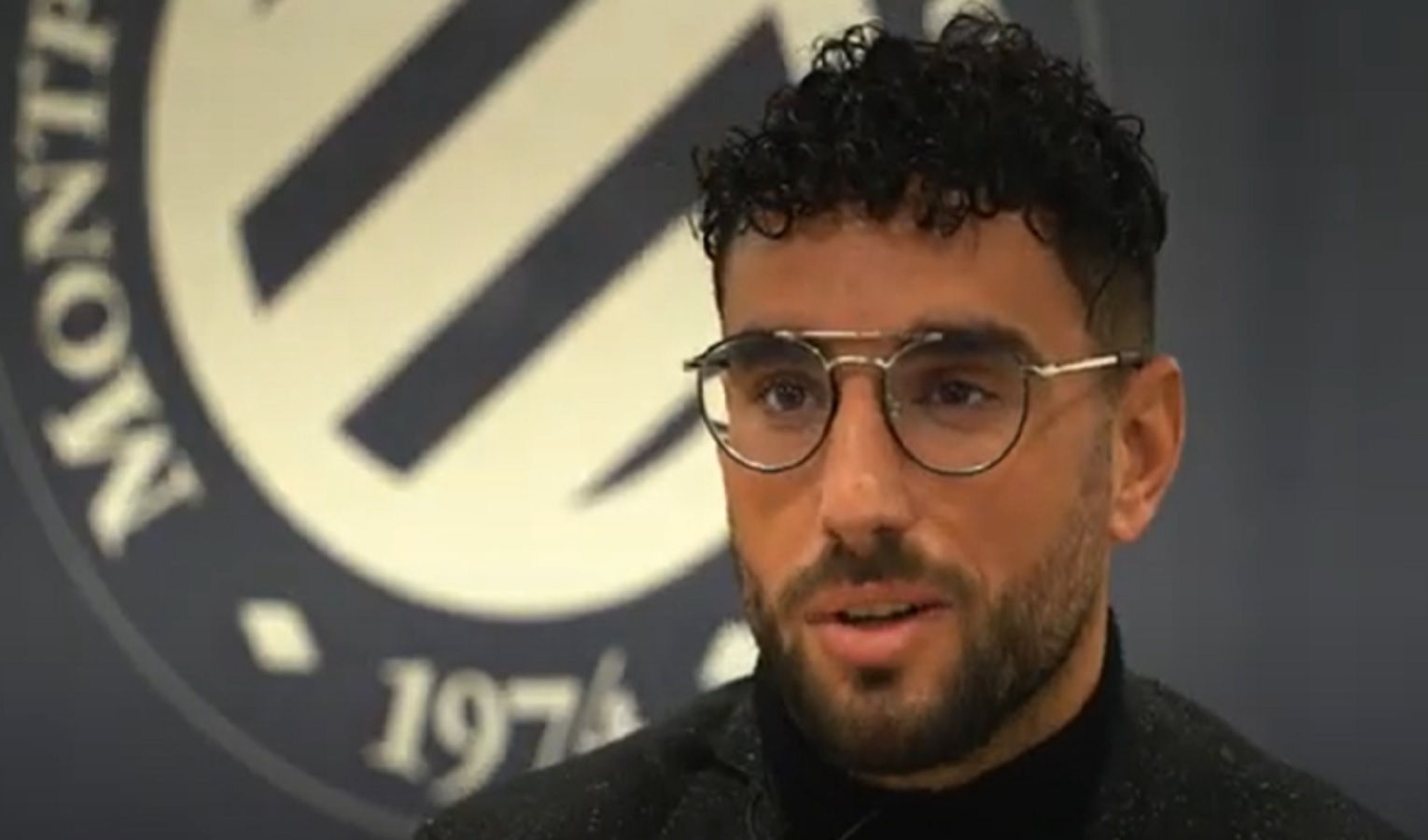 Un uomo moro, barba e occhiali