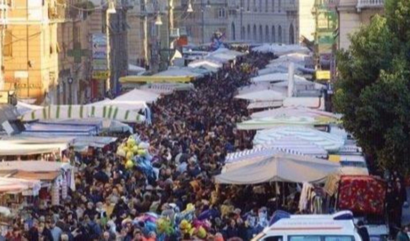Gente che cammina in una strada dove è in corso una fiera
