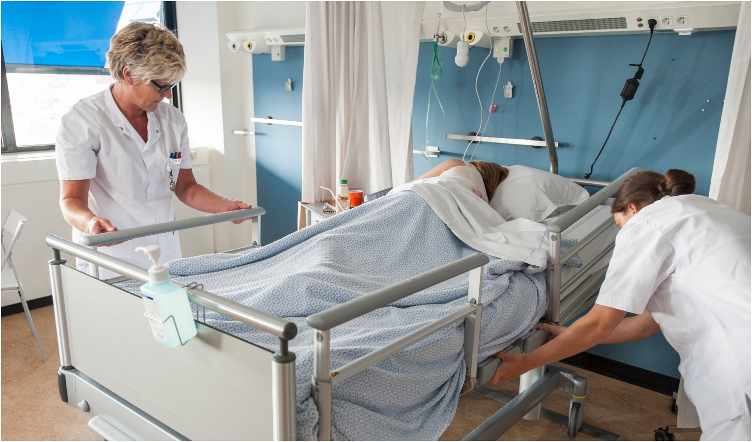 Letto di ospedale con due infermiere