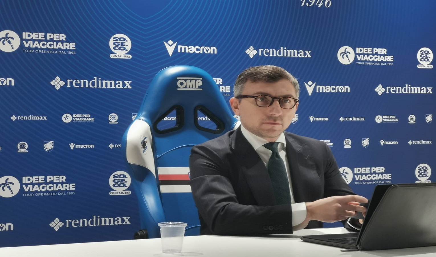 Un uomo seduto al computer prima di una conferenza