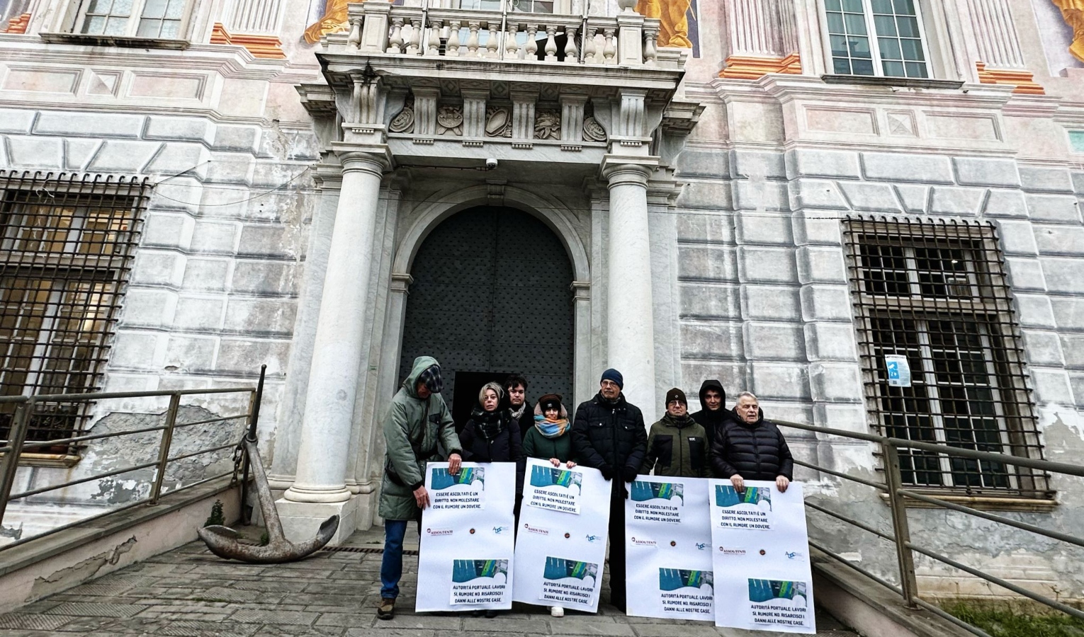 Il primo presidio davanti a palazzo San Giorgio Otto persone con cartelli davanti alla porta di un palazzo storico