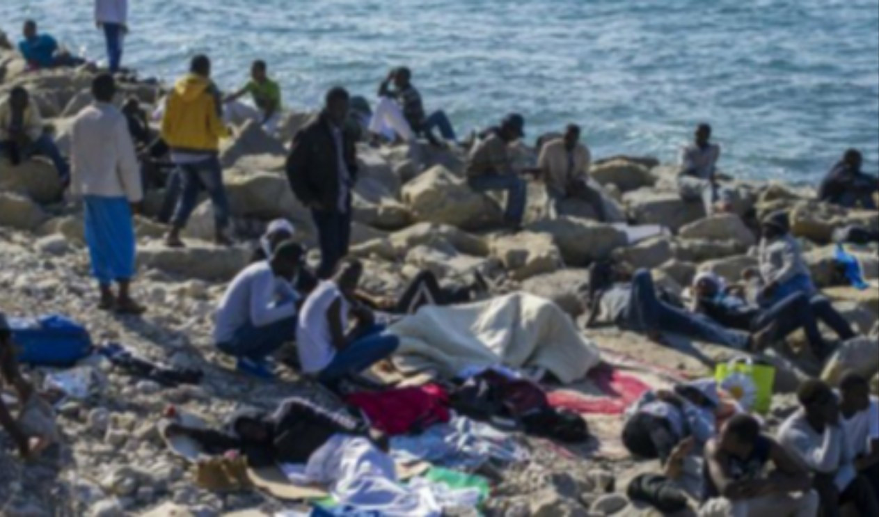 Migranti a Ventimiglia Persone sedute su uno scoglio