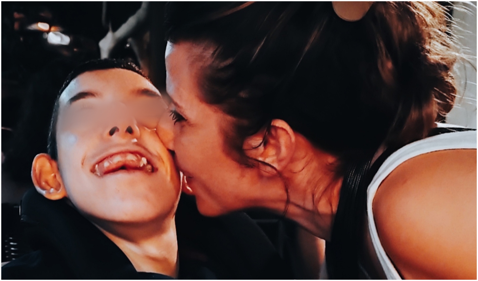 Donna dà bacio sulla guancia a ragazzino disabile