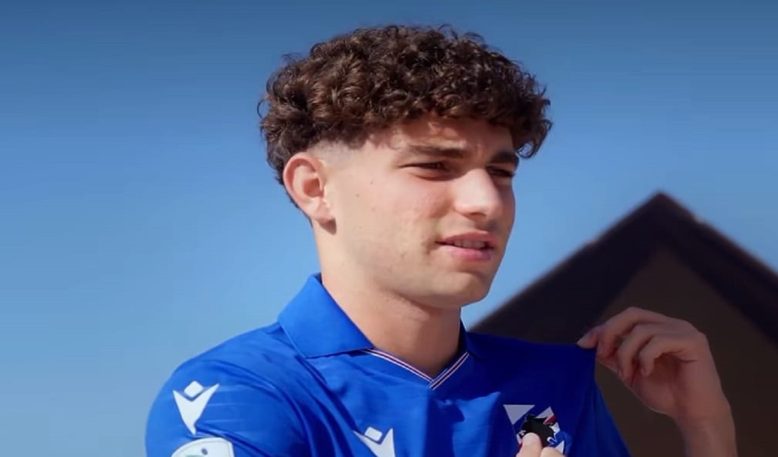 Un ragazzo coi capelli riccioli indossa la maglia della Sampdoria