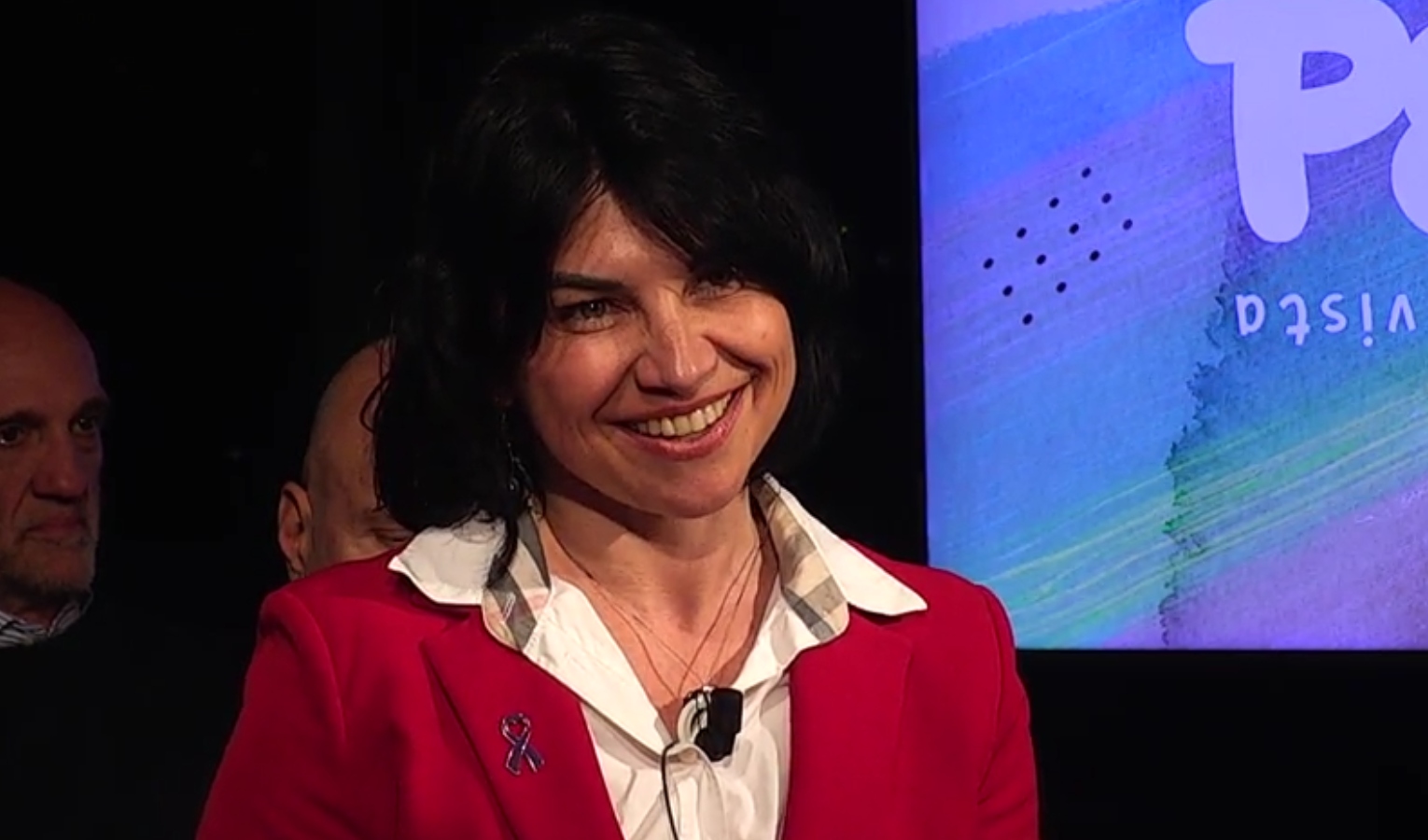 Donna sorridente in studio televisivo