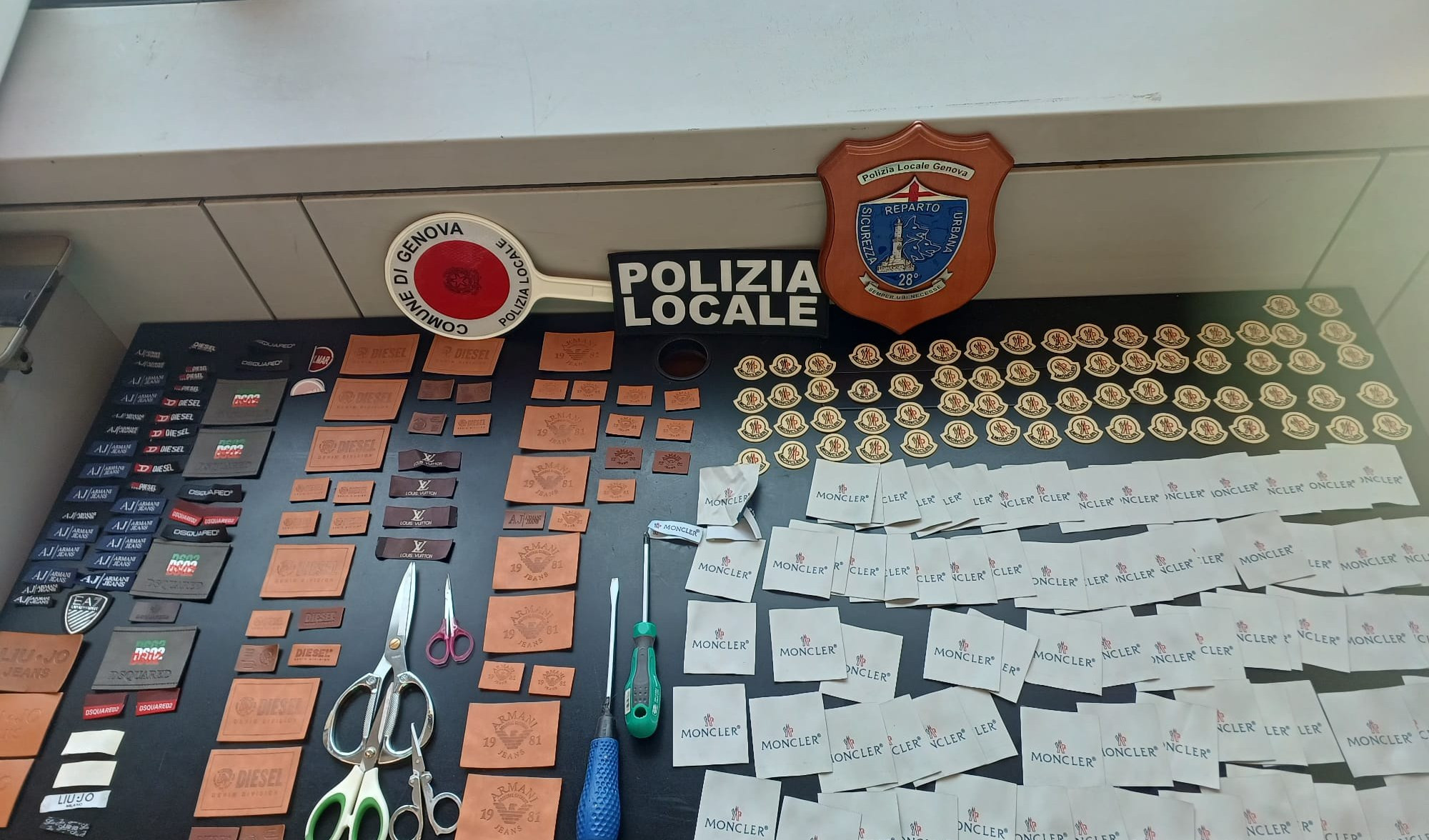 Genova, in un appartamento un laboratorio di marchi falsi: sequestrate 2900 etichette firmate 