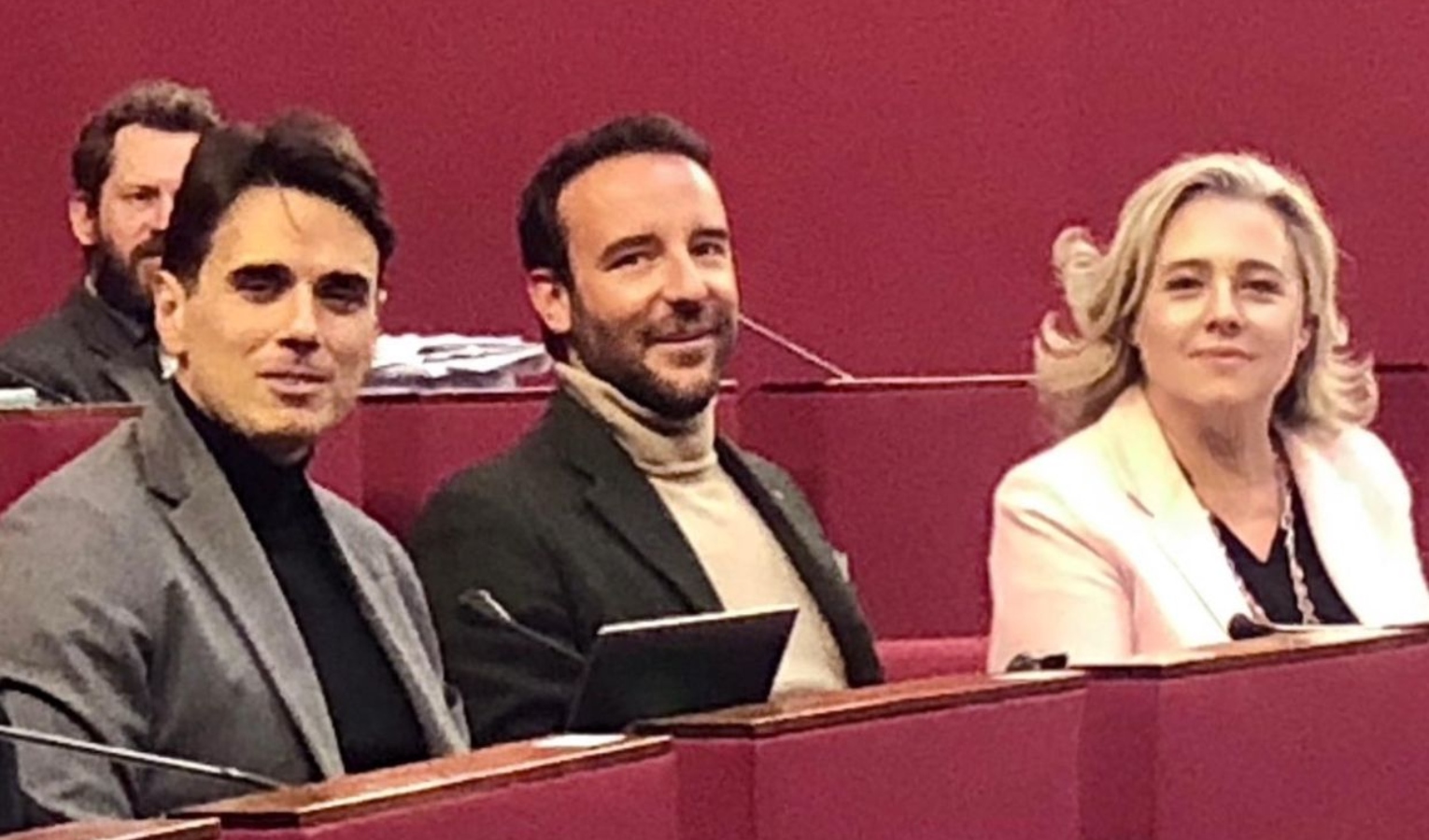 Paolo Gozzi, Stefano Costa, Arianna Viscogliosi Tre persone, due uomini e una donna, seduti tra i banchi rossi di un'aula di consiglio comunale