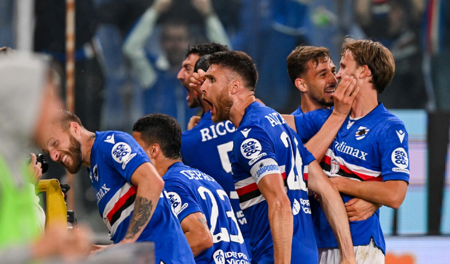 Alcuni calciatori della Sampdoria urlano, sorridono, si abbracciano e festeggiano