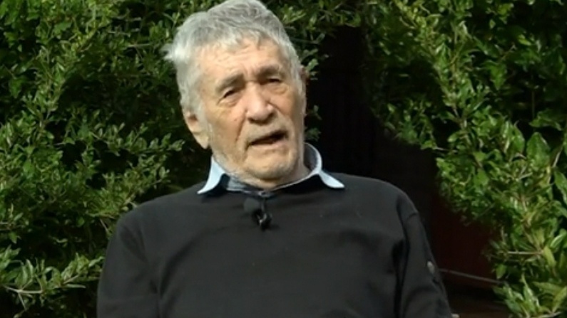 un uomo in camicia e maglione
