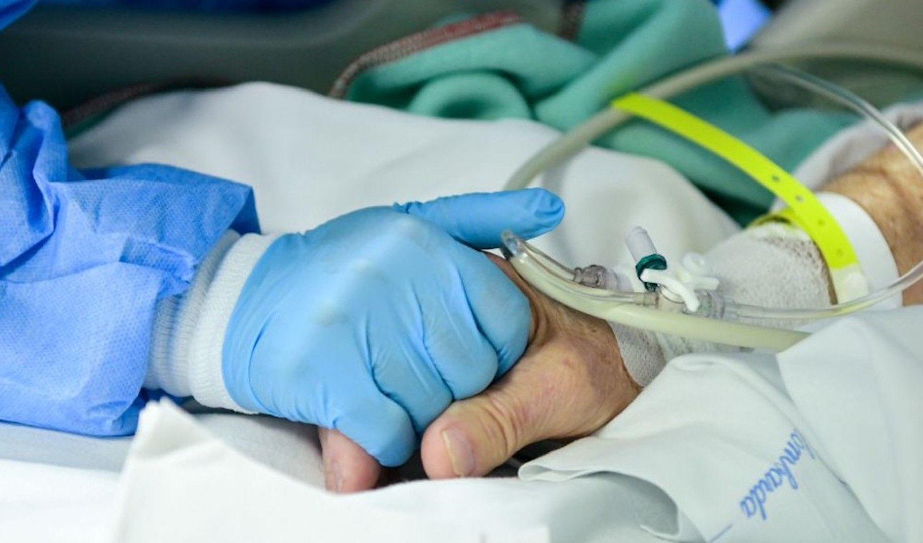 Caso grave di influenza a Genova Una mano con un guanto blu stringe un'altra mano