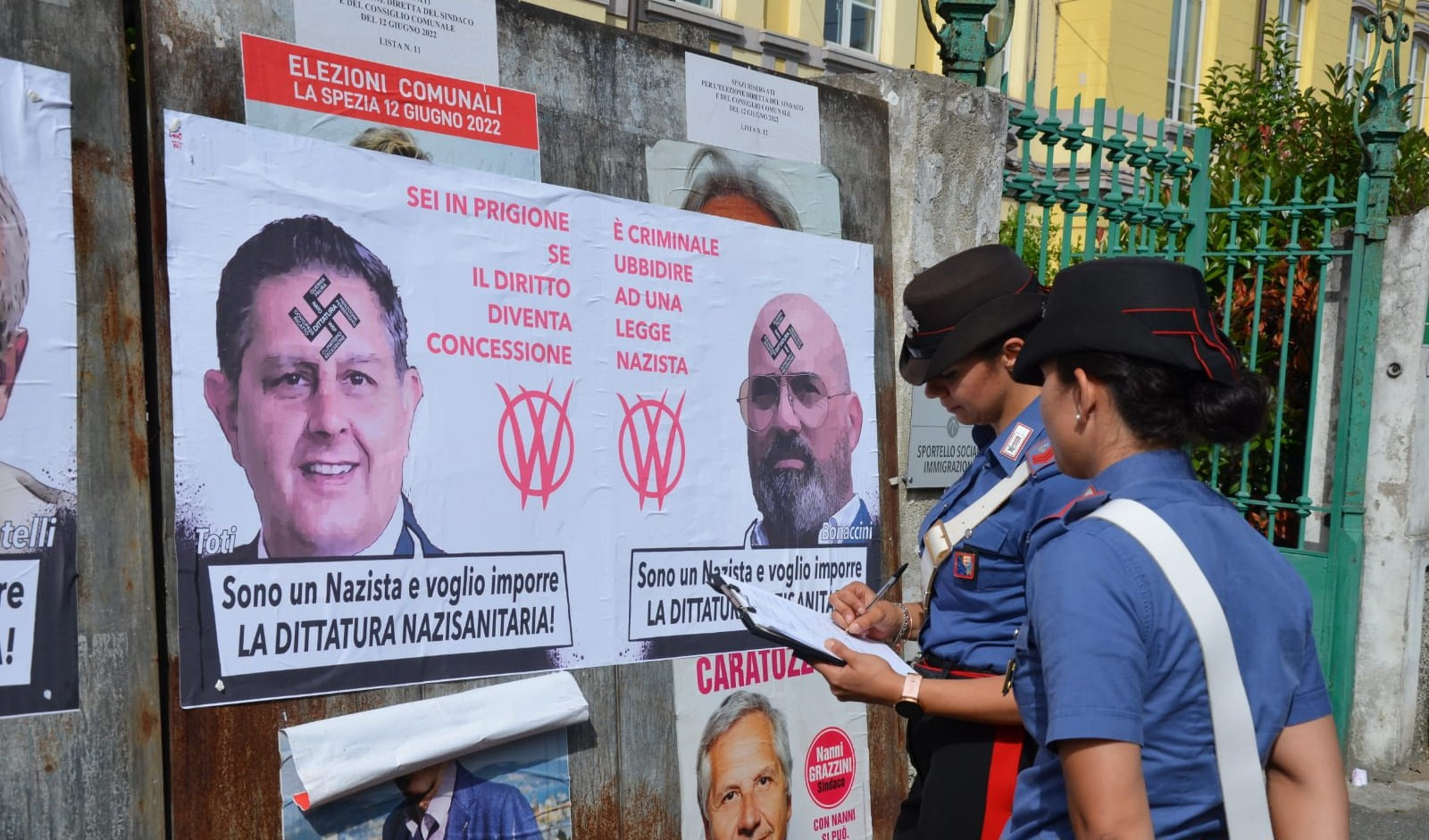 Manifesti no vax sui tabelloni elettorali, svastiche e scritte: indagini alla Spezia