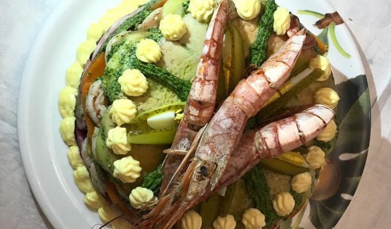 Tanto pesce sulla tavola delle feste di Natale Torta con gamberoni sopra
