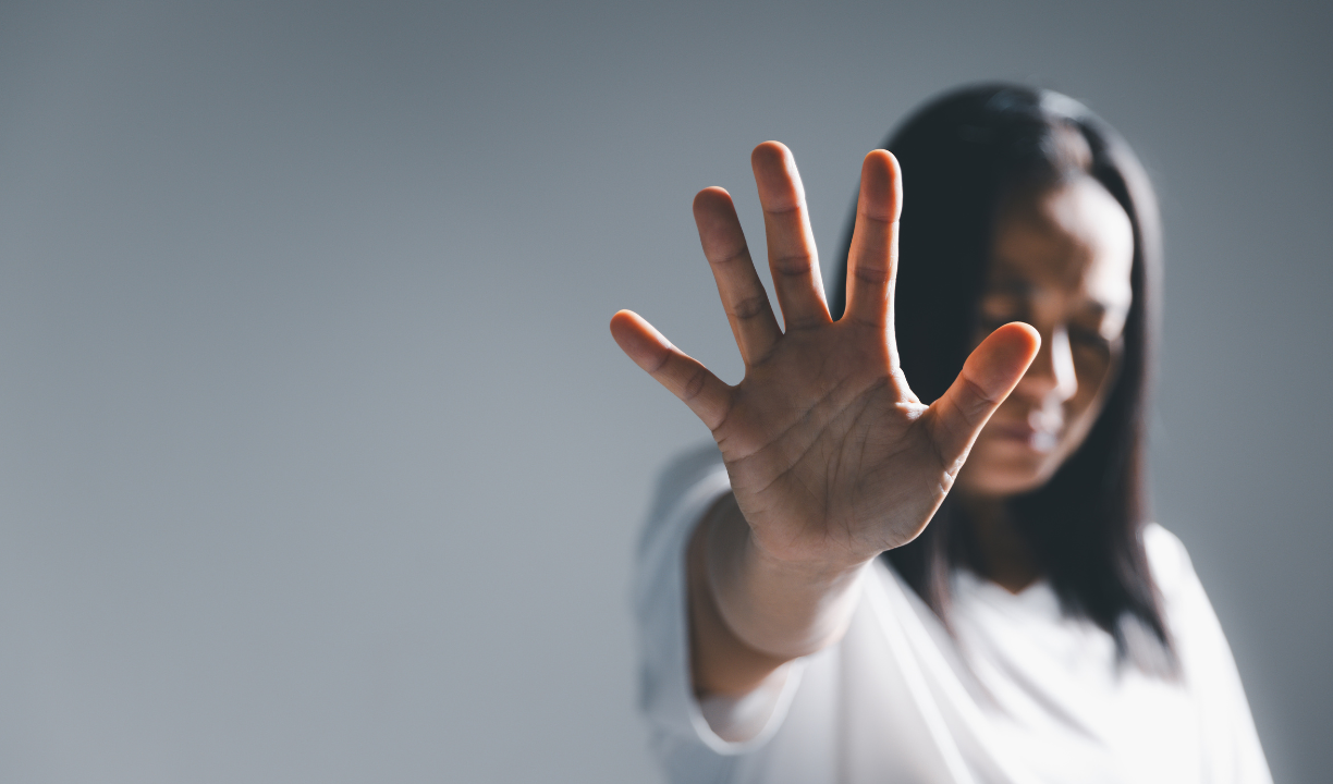donna con il braccio destro alzato e la mano aperta