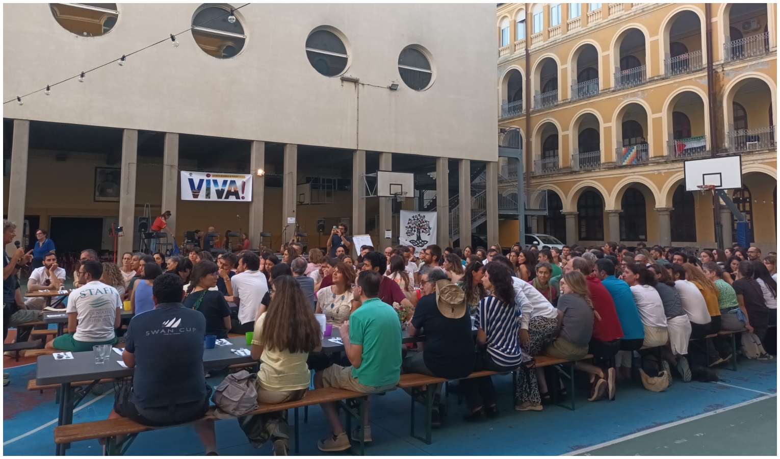 La cena condivisa all'aperto del 1 giugno dei 200 giovani arrivati da tutta Italia Persone sedute su panche all'aperto