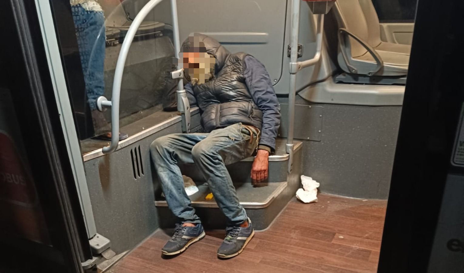 Persona accasciata sui sedili di un autobus