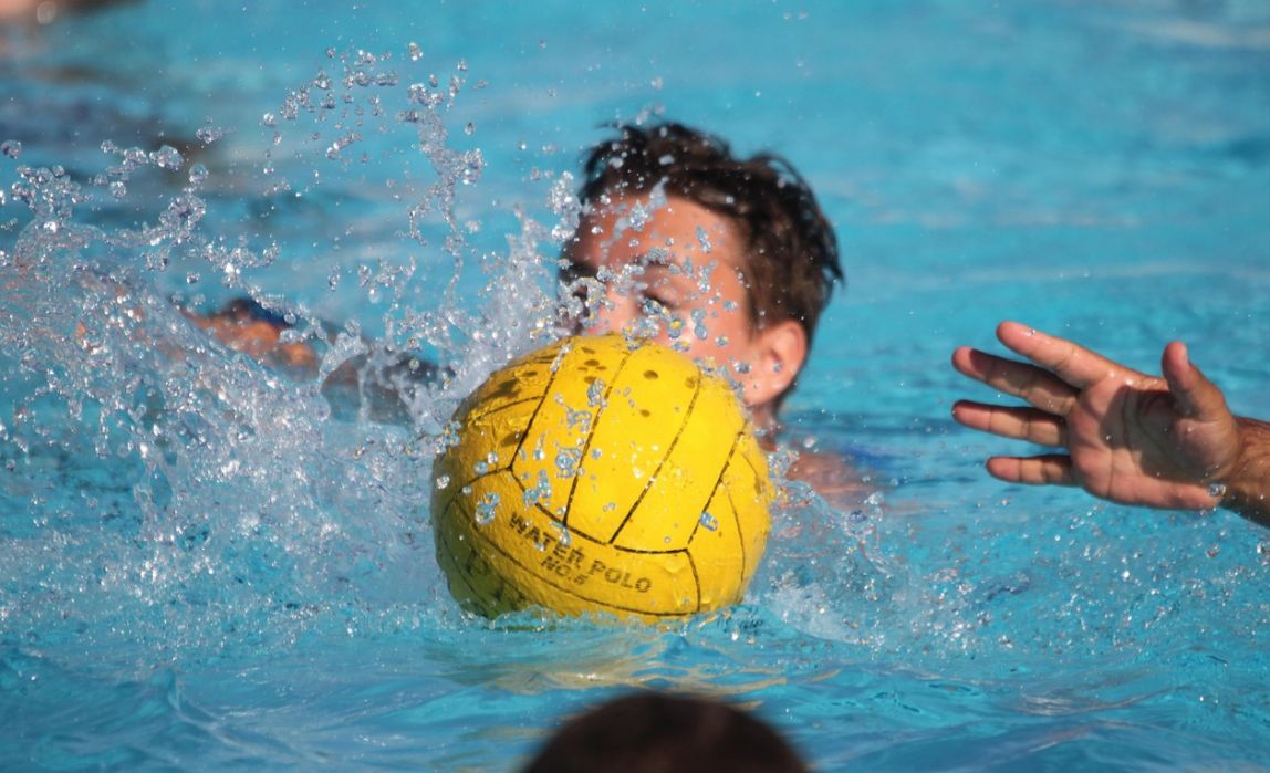 Un bambino che gioca in piscina con la palla